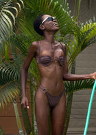 Person holding a hose among palm leaves