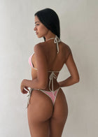 Woman wearing a pink and white bikini against a plain background